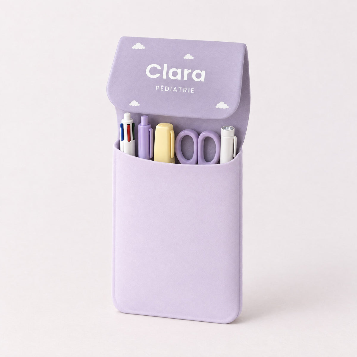 Pochette ouverte : stylos, surligneur, ciseaux et lampe stylo rangés debout