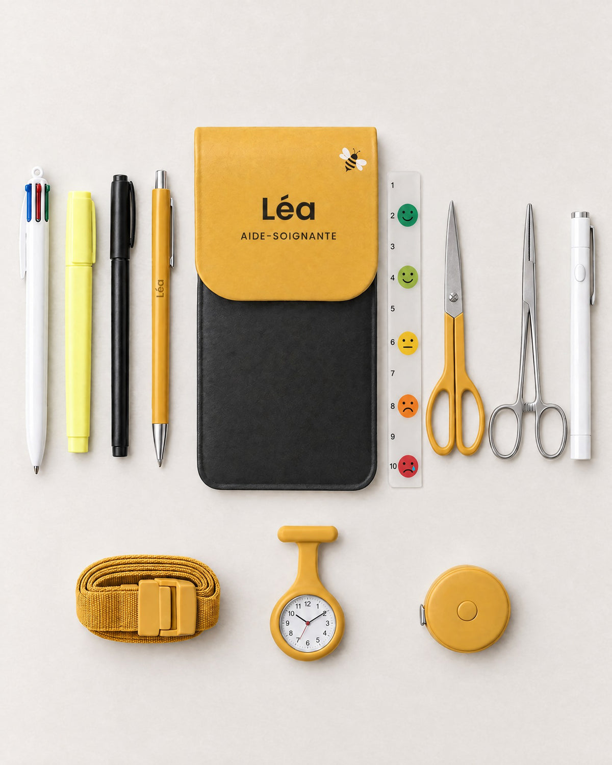 Kit complet Petite abeille : la pochette avec sa réglette douleur, stylo 4 couleurs, surligneur, feutre, ciseaux, stylo gravé, pince Kocher, lampe stylo, garrot, montre infirmière et mètre ruban